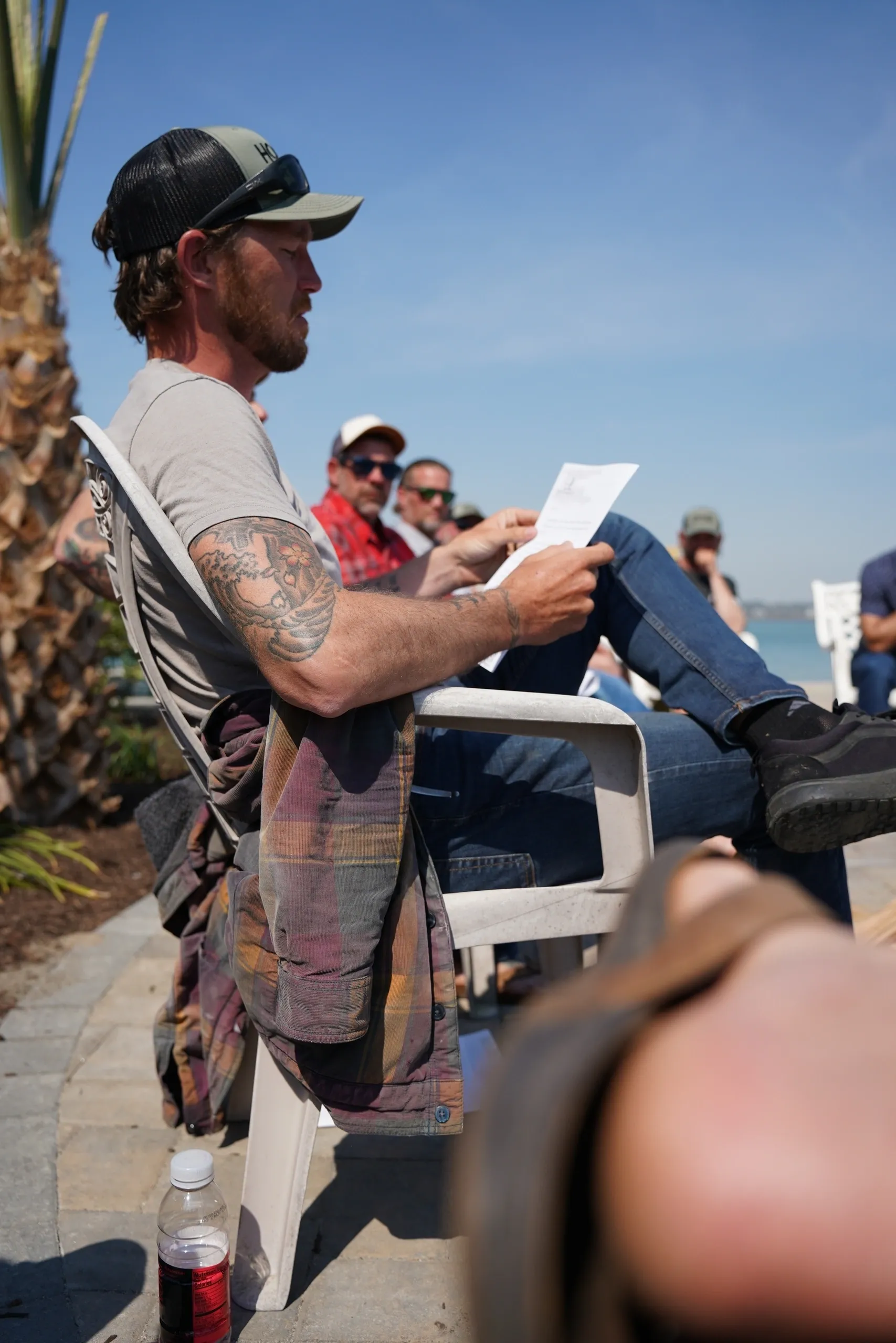 Man reading paper outdoors with group