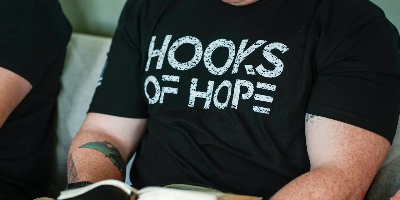 Tattooed arm holding a book